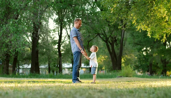 Pai e filho a pisar o gramado do parque — Fotografia de Stock