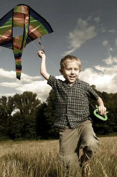 Criança joga feliz com kite — Fotografia de Stock