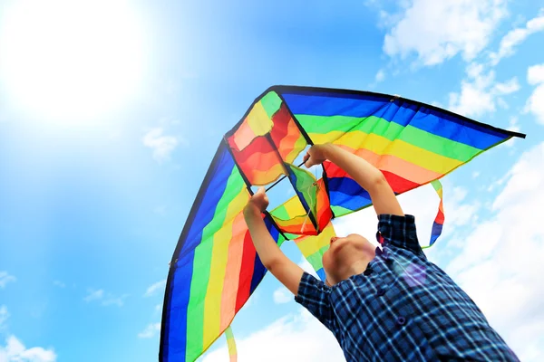 Llittle boy flies a kite in the sky — Stock Photo, Image