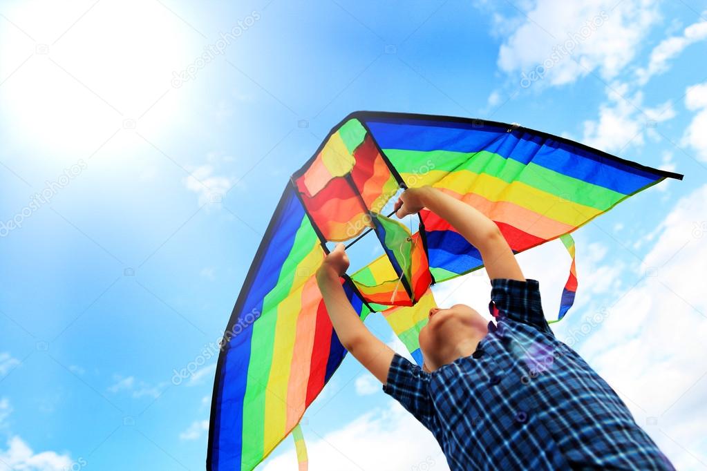 Llittle boy flies a kite in the sky