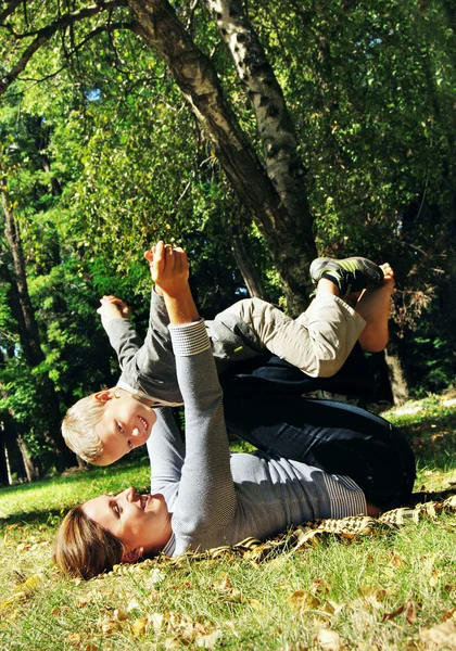 Motther y su hijo en el césped del parque — Foto de Stock