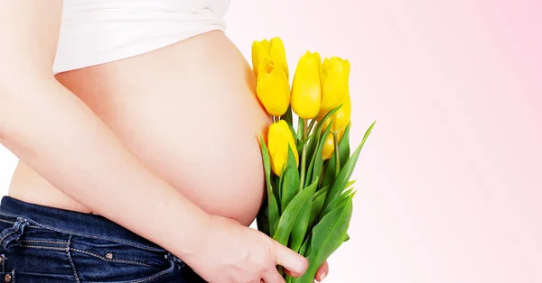 Mujer embarazada barriga con tulipanes —  Fotos de Stock