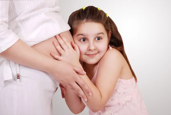 Daughter listen near pregnant mom tummy — Stock Photo, Image