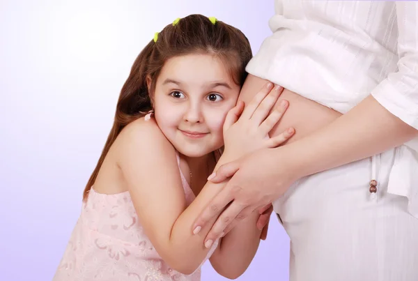 Daughter listen near pregnant mom tummy — Stock Photo, Image