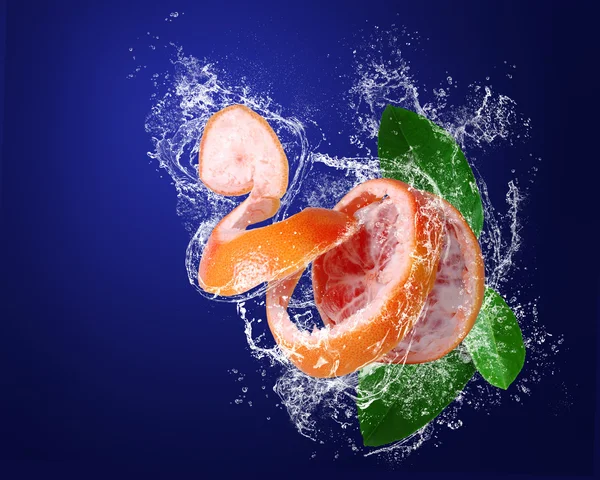 Red grapefruit with leaves in water splashes — Stock Photo, Image