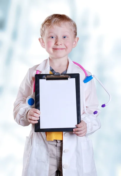 Улыбаясь маленький мальчик в униформе врач — стоковое фото