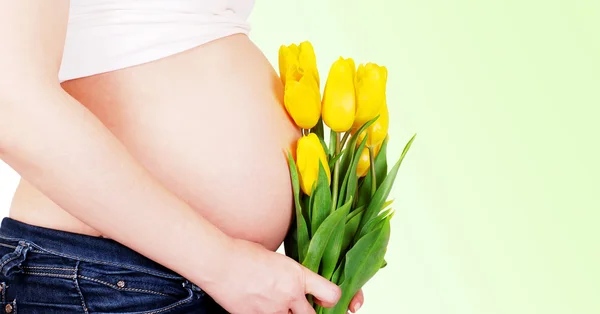 Těhotná žena bříško s tulipány — Stock fotografie