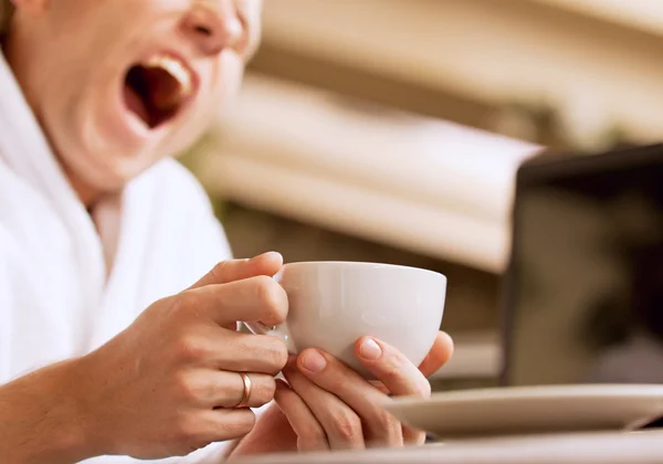 Yawning sleepy man with cup of coffee in hand — kuvapankkivalokuva