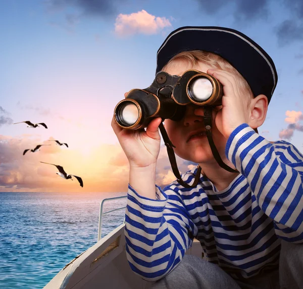 Sailor boy with binoculars in the boat — Stock Photo, Image