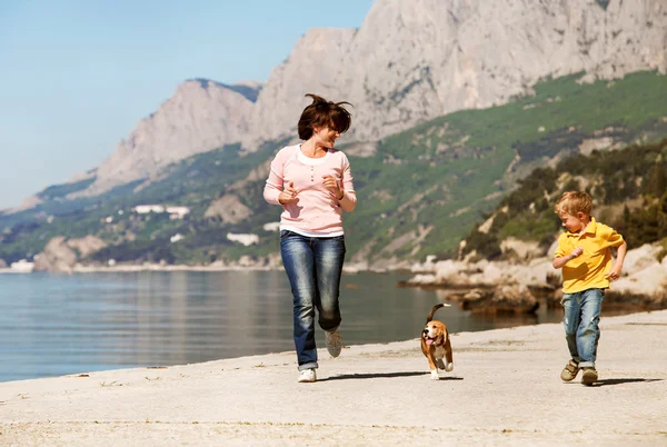 Spelen en gelukkige familie met hond — Stockfoto