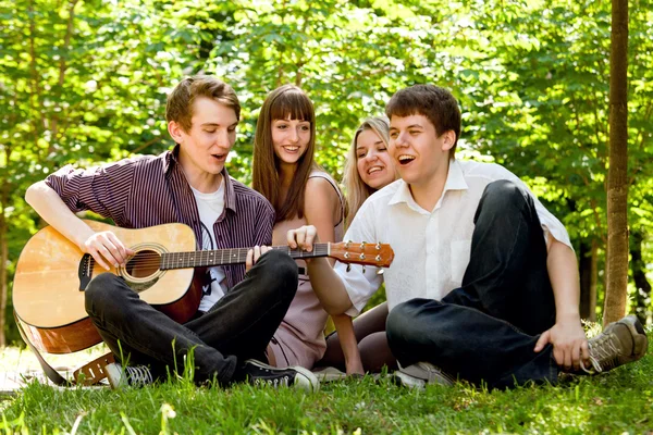 Vier Freunde singen mit Gitarre — Stockfoto