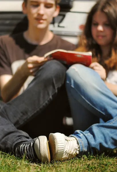 Young couple read the guidebook sitting near car — Stock Photo, Image