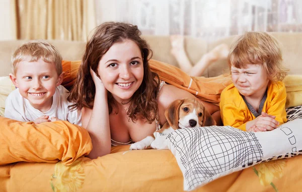 Hermano y hermanas en la cama con cachorro —  Fotos de Stock