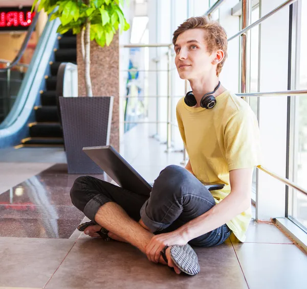 Garoto adolescente navegar internet no moderno centro comercial — Fotografia de Stock