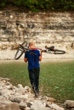 genç adam, Bisiklet omuzlarında taşımak