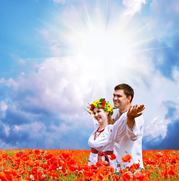 Happy couple on poppies field – stockfoto