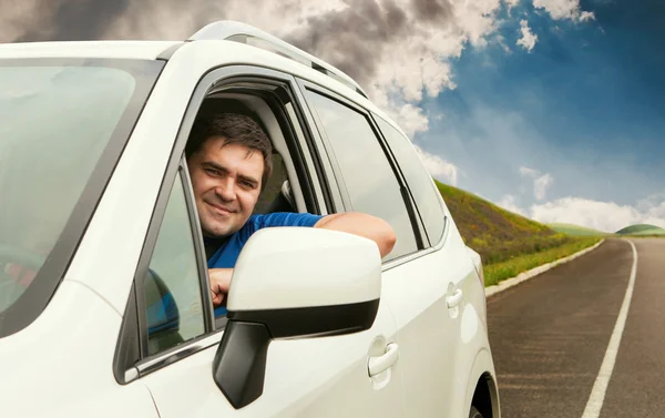 Az ember a kocsija a magányos közúti vezetéssel — Stock Fotó