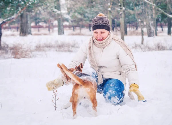 Mujer jugando con su mascota en el parque de invierno —  Fotos de Stock