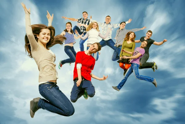 Amigos adolescentes felizes pulando no céu — Fotografia de Stock