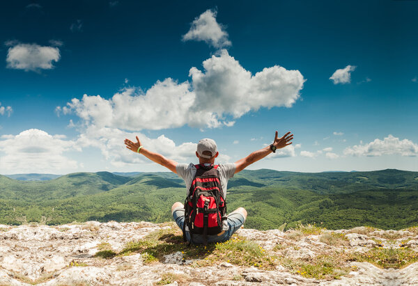 Man greeting amazing rich nature on the top of mountain