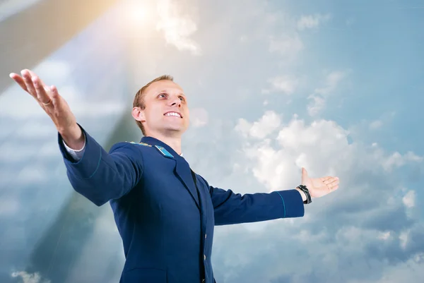 Mavi gökyüzü arka plan üzerinde mutlu bir genç adam uçak pilotu — Stok fotoğraf