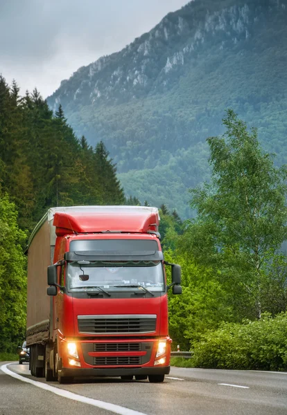 Red truck on mountain highway in the evening — Stock Photo, Image