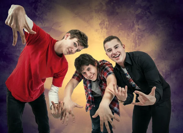 Три молодих чоловіка в веселих позах хіп-хопу — стокове фото