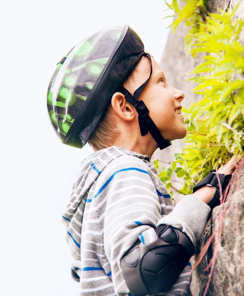 石造りの壁に屋外クライミングの練習の少年 — ストック写真