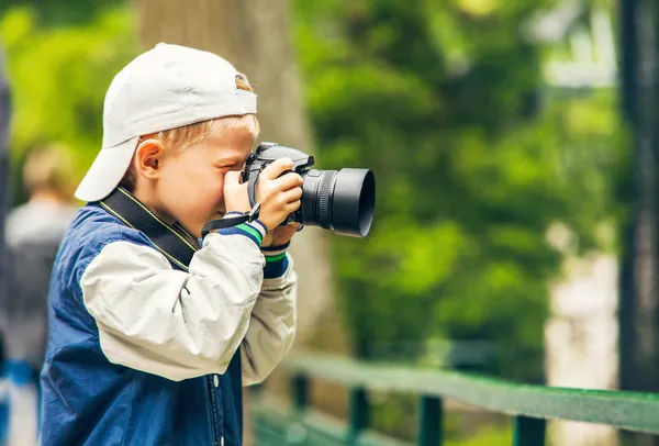 Little boy with photo camera makes a shoot — Stok Foto