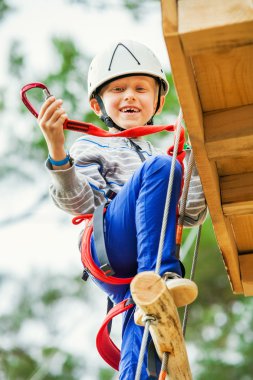 chłopiec na linowy tor przeszkód