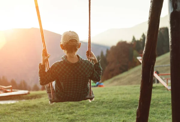 Little Boy Dondolava Sul Parco Giochi Bambini Montagna Nei Raggi — Foto Stock