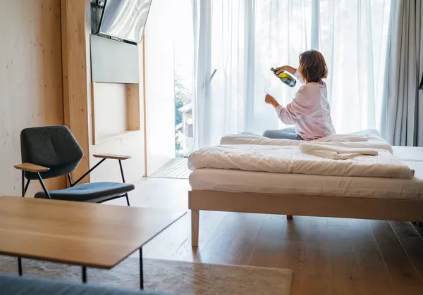 Einsame Frau Sitzt Auf Einem Modern Möblierten Hotelzimmerbett Neben Dem — Stockfoto