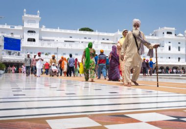 Amritsar, Hindistan - 15 Ağustos 2016, Amritsar, Panjab, Hindistan 'da altın tapınağın mermer taş zemininde yürüyen Hintli Sih ihtiyarın portresi.
