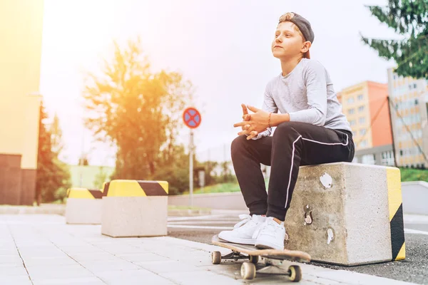 青少年滑板男孩肖像画在城市街道上的棒球帽与老滑板 自由时间消费与积极的人的观念形象 — 图库照片