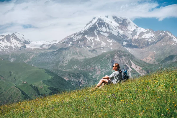 Backpacker Woman Sitting Green Grass Hill Enjoying Snowy Slopes Kazbek — Stockfoto