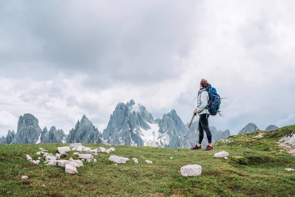 意大利南部蒂罗尔的Tre Cime Lavaredo组附近 一个背着背包 脚踏两极的女远足者在山上欣赏着风景如画的白云石阿尔卑斯山 积极的人与山区概念 — 图库照片