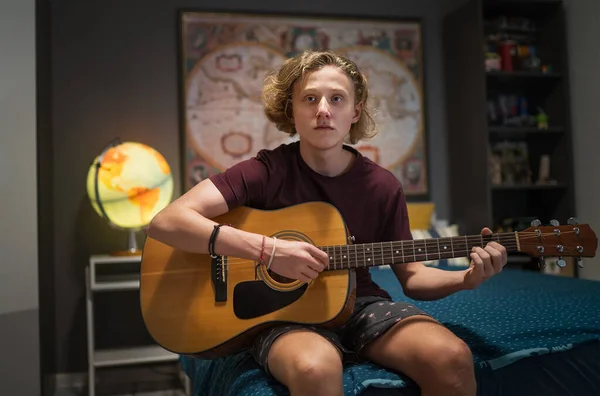 Retrato Adolescente Sentado Sofá Acolhedor Tocando Guitarra Acústica Vestida Roupas — Fotografia de Stock