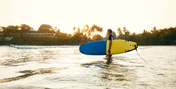 Teen Boy Blue Yellow Surfboard Entering Waves Surfing Sunset Rays — Stock Photo, Image