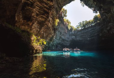 Melissani Mağara Gölü, Sami, Yunanistan 'da turistlerle dolu yüzen tekneler..