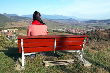 Lonely girl at bench & High Tatras mountains clipart