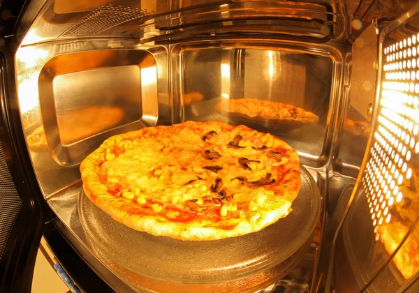 Pizza inside microwave — Stock Photo, Image