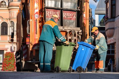 RUZOMBEROK, SLOVAKIA - 12 Ekim 2021: Çöp kamyonuna çöp yükleme işlemi. Çöp toplayıcıları