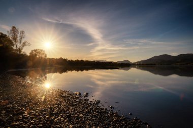 Su seviyesindeki güneş ışınlarının güzel bir yansıması. Slovakya 'daki Liptovska Gölü Mara