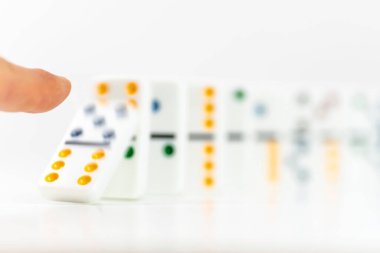 Parmak, domino taşının bir kısmını itti. Domino etkisi. İş konseptinde risk ve strateji.