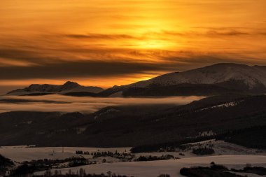 Karlı kış dağ manzarası ve Slovakya 'daki Dumbier ve Chopok tepelerinde gün doğumundan sonra renkli gökyüzü..