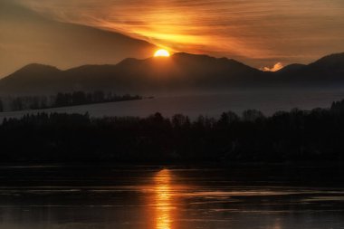Büyük güneş ve gün doğumunda renkli gökyüzü. Slovakya 'nın Alçak Tatras dağlarındaki Krakova Hola Tepesi.