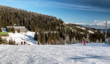 SMREKOVICA, SLOVAKIA - 9 Ocak 2021: Great Fatra dağlarındaki Smrekovica tatil beldesinde kayakçılar. Arkaplanda Yüksek Tatras
