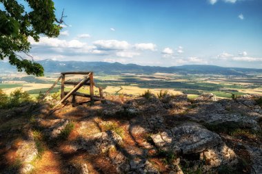 Slovakya 'nın Ondrasovska skala adlı bir tepede yaz manzarası olan boş bir bank..