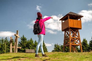 Sırt çantalı kız yürüyüşçü Slovakya 'daki Javorniky dağlarındaki Stratenec tepesine bakıyor.