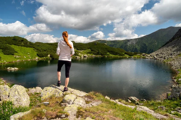 stock image Girl tourist standing and looking on beautiful nature with lake and summer mountains in Western Tatras in Slovakia. Hiking theme.